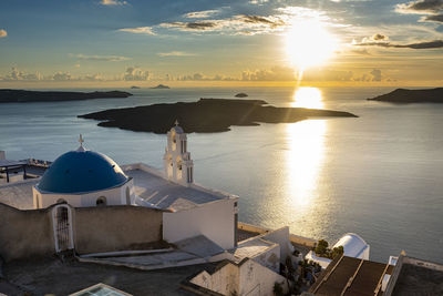 High angle view of sea and buildings against sky during sunset