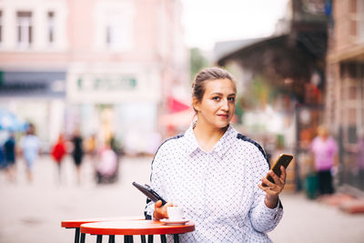 Young woman using mobile phone in city