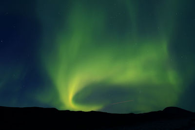 Low angle view of silhouette mountain against sky at night