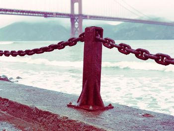 Close-up of metallic structure against sea