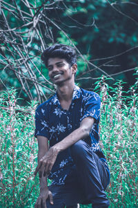 Young man looking away in forest