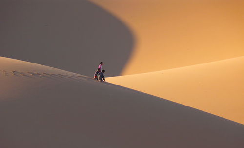 People walking on sand dune in desert