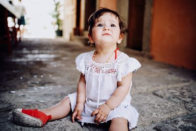 Portrait of cute girl sitting outdoors