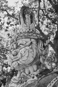 Close-up of angel statue against trees