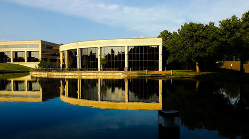 Reflection of building in lake against sky