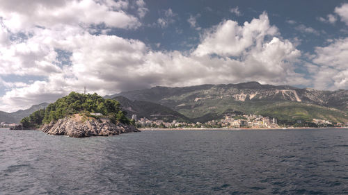 Scenic view of sea and mountains against sky