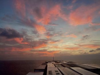 Scenic view of sea against dramatic sky during sunset