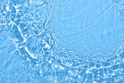Transparent blue colored clear calm water surface texture