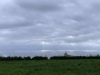 Scenic view of grassy field against sky