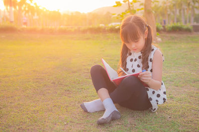 Full length of girl sitting on grass