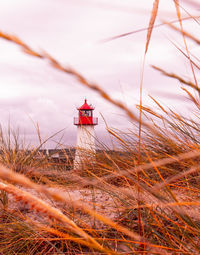 Lighthouse on land against sky