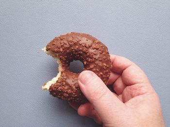 Close-up of cropped hand holding donut