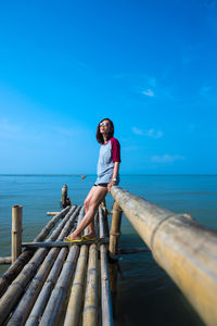 Man standing on pier at sea