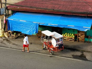 High angle view of woman walking on street by stall