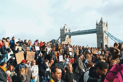 People on bridge against sky