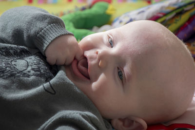 Close-up portrait of cute baby lying on bed