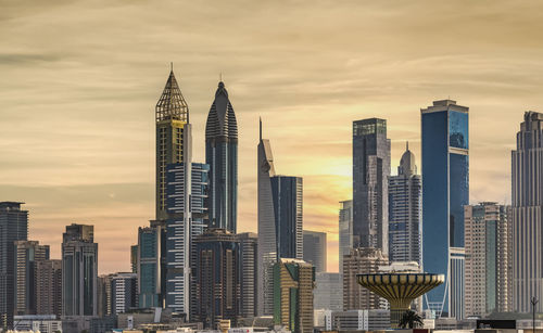 Skyscrapers in city against sky during sunset