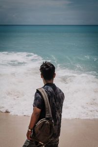 Rear view of man looking at sea shore