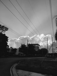 Cars on road against cloudy sky