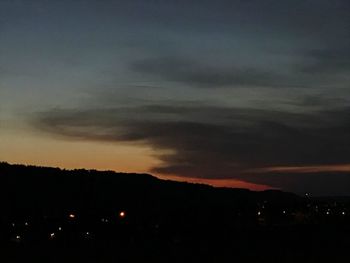 Silhouette mountains against sky at night