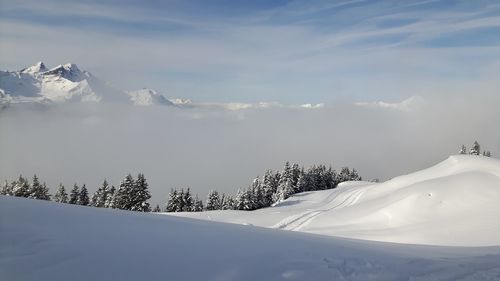 Scenic view of snow covered mountains against sky