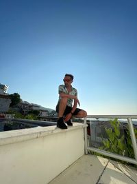 Low angle view of man against clear blue sky