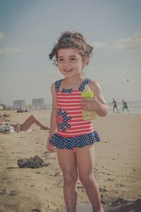 Portrait of girl on beach against sky