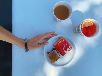 High angle view of woman holding coffee cup on table