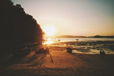 Scenic view of beach against clear sky during sunset