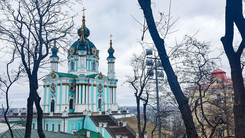 Low angle view of trees and building against sky