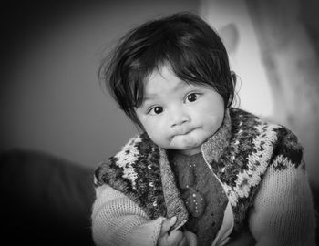 Portrait of cute baby girl wearing warm clothing at home