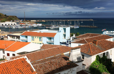 High angle view of houses by sea against sky