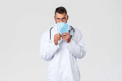 Portrait of man standing against white background