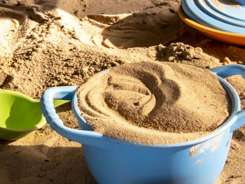 High angle view of coffee cup on sand