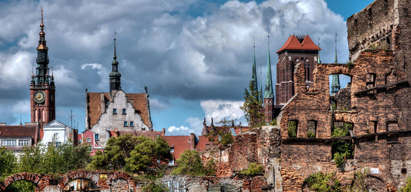 Old buildings against cloudy sky