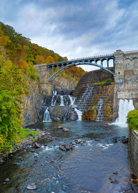 Arch bridge over river against sky