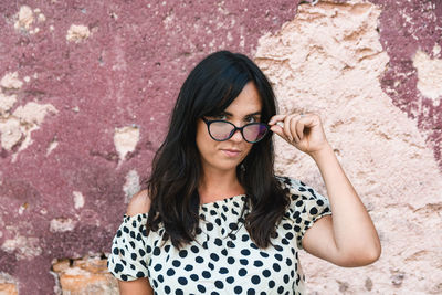 Portrait of woman standing against wall