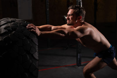 Shirtless man exercising in gym