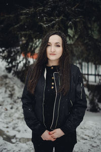 Portrait of young woman standing in snow