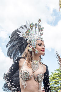 Young woman wearing mask against sky