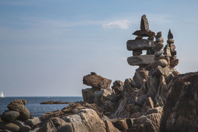 Stack of rocks on beach against sky