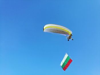 Low angle view of paraglider in mid air with bulgarian flag