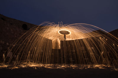 Low angle view of wire wool against sky at night