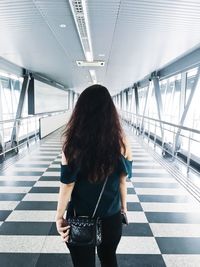 Rear view of woman standing on walkway