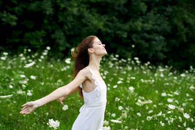 Side view of a young woman standing outdoors