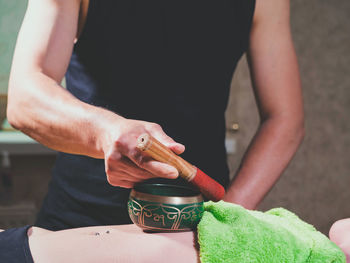 Midsection of mid adult man giving massage to woman in spa