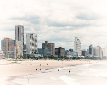 City at beach against sky