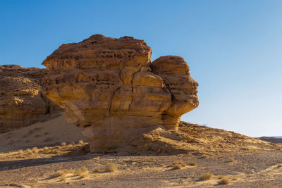 Rock formations in desert against clear blue sky