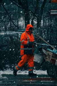 Man standing on snow covered trees during winter