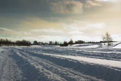 Scenic view of snow covered landscape against cloudy sky